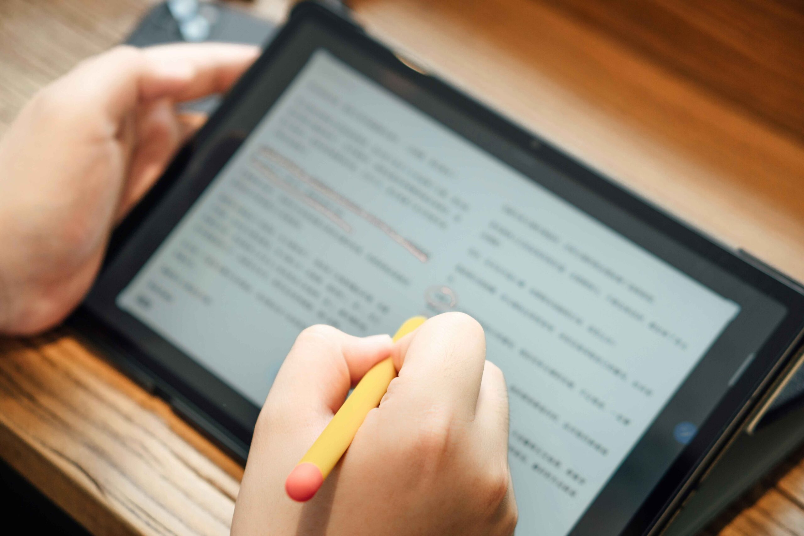 person using stylus to edit a paper on a tablet