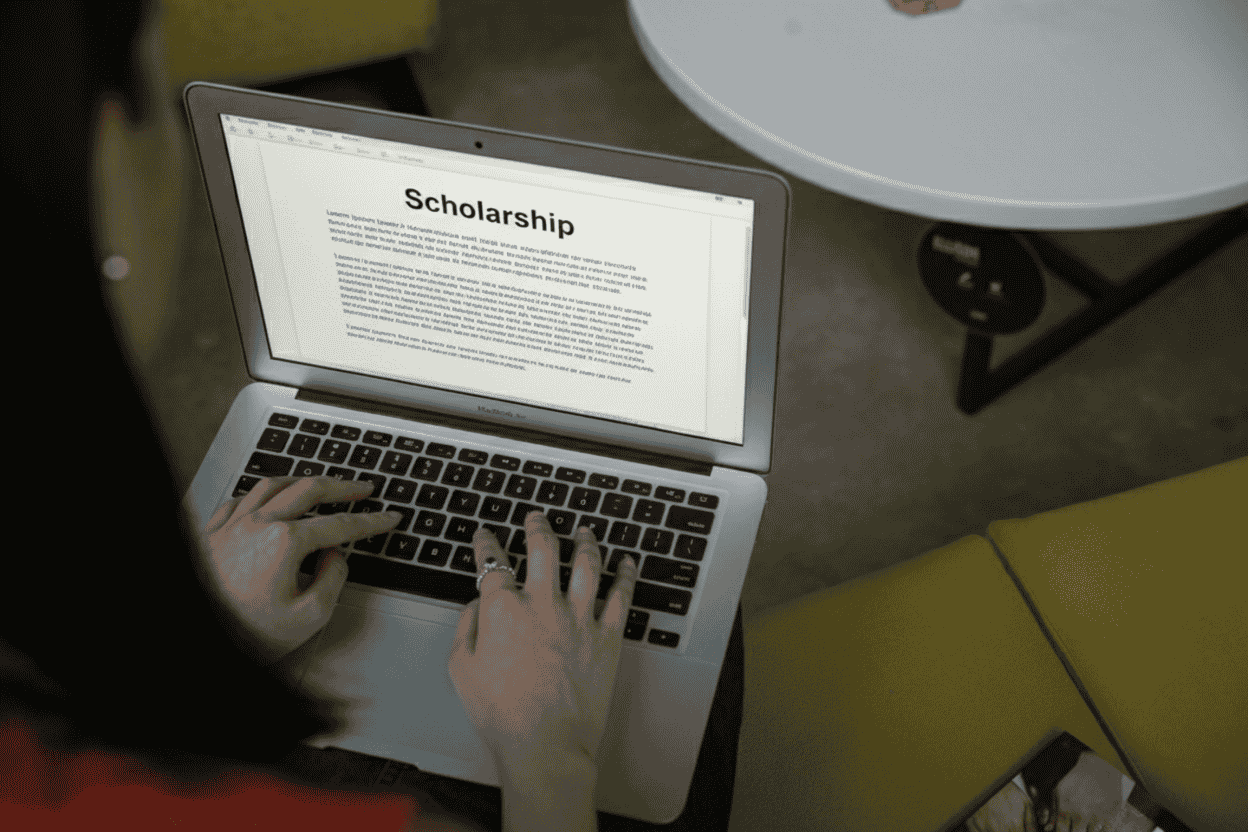 person typing a scholarship essay on a laptop