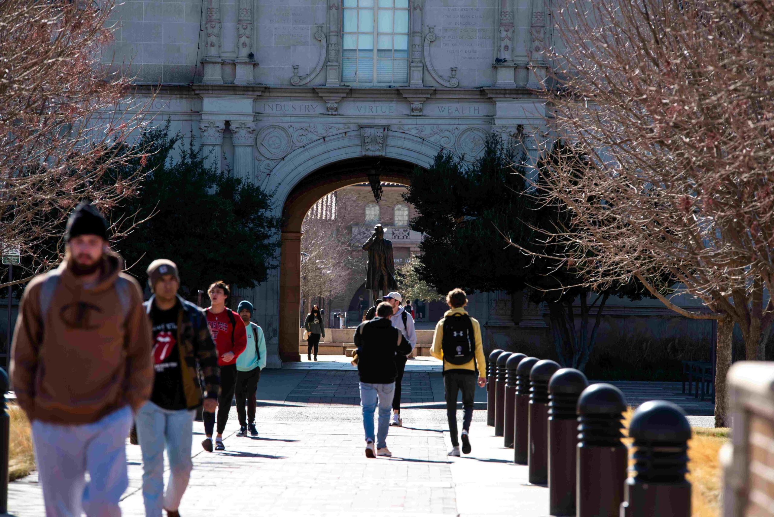 students walking into and out of the college gate